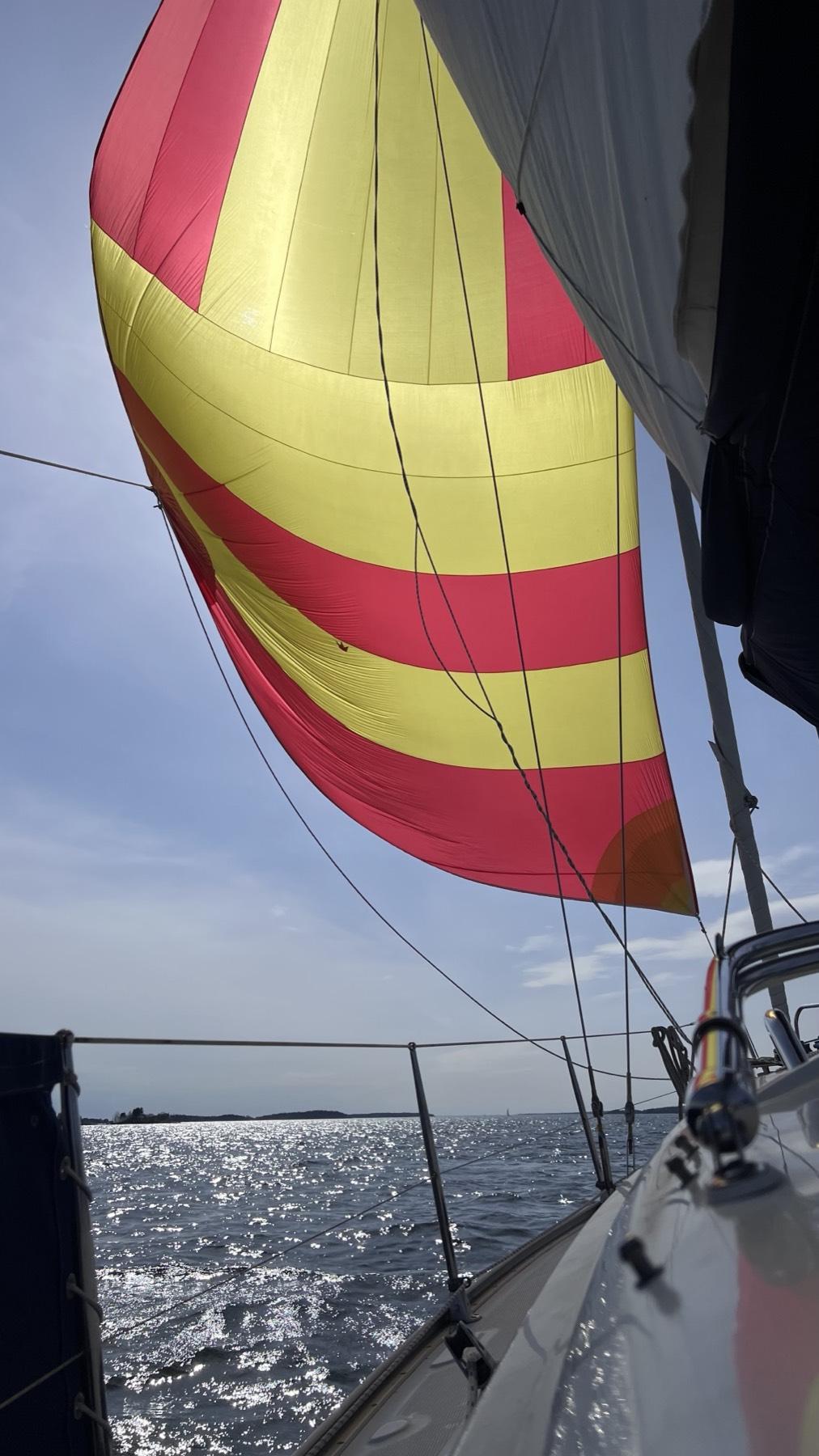 A striped spinnaker filled with wind on the Helsinki archipelago