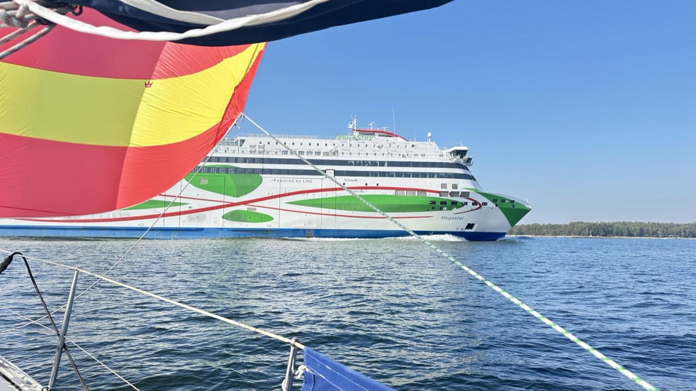 A spinnaker in the foreground with a Tallinn ferry passing behind